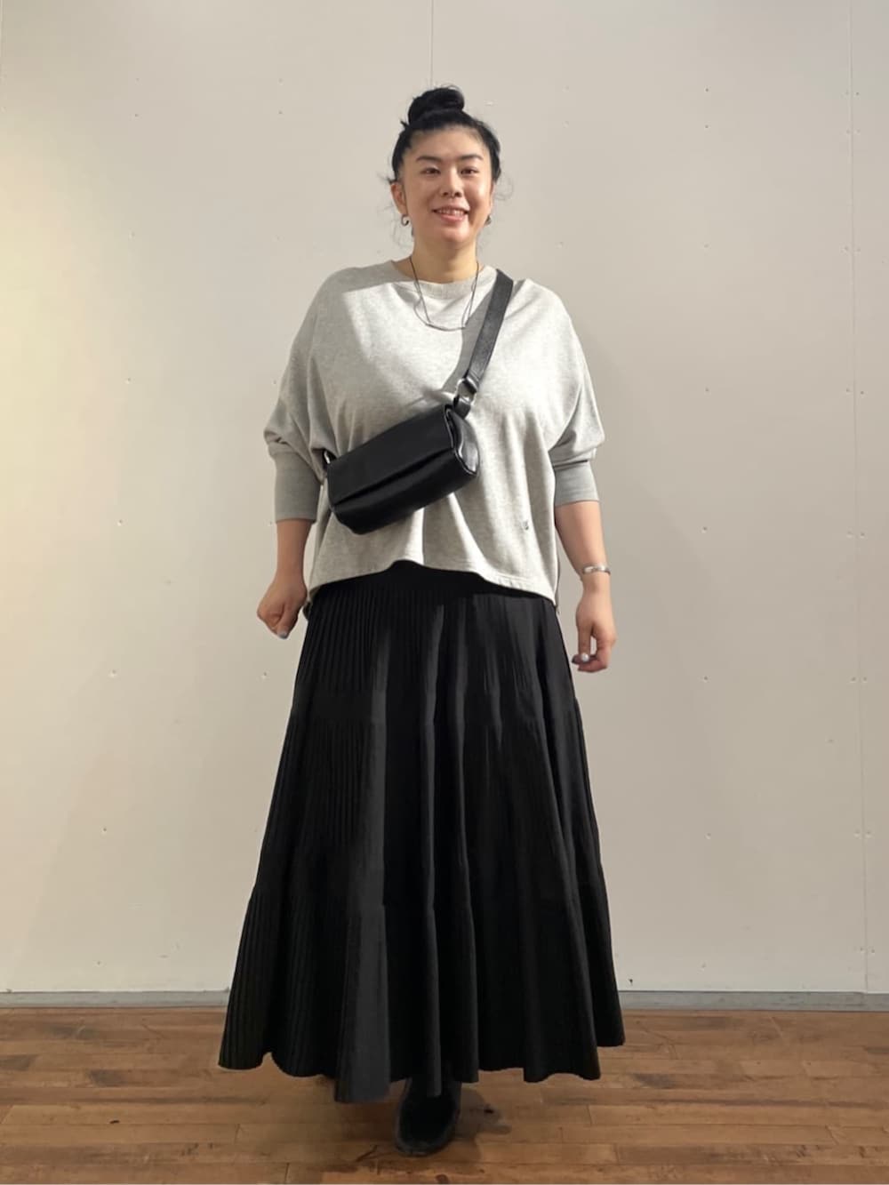 ブラック系のスカート、グレー系のTシャツ/カットソーを着用したレディースの夏コーディネートの2枚目の写真