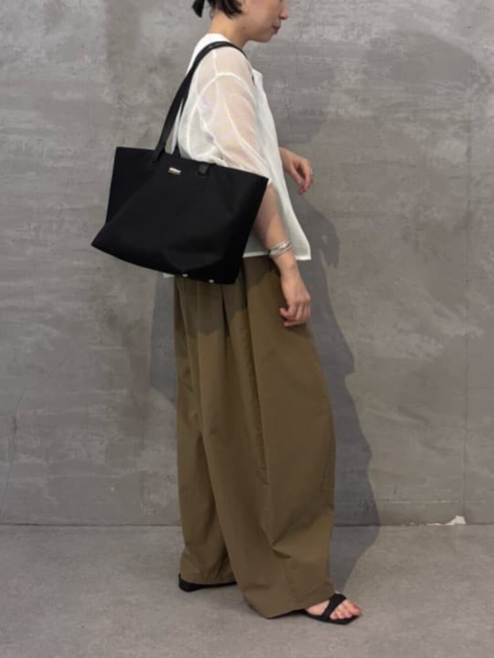 イエロー系のその他パンツ、ホワイト系のシャツ/ブラウス、ブラック系のトートバッグを着用したレディースの春コーディネートの5枚目の写真