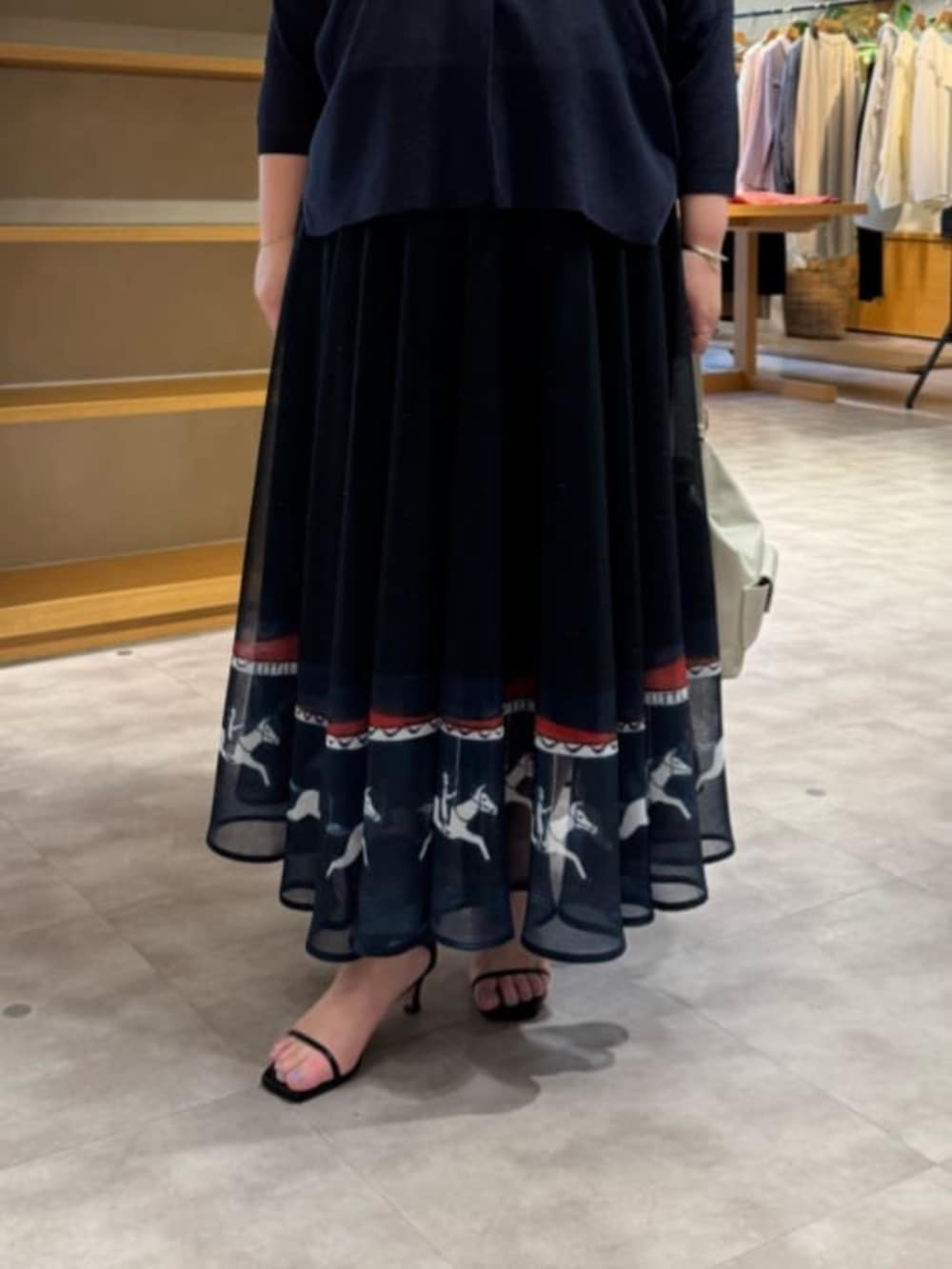 ホワイト系のトートバッグ、ブルー系のカーディガン/ボレロ、ブルー系のスカートを着用したレディースの春コーディネートの8枚目の写真