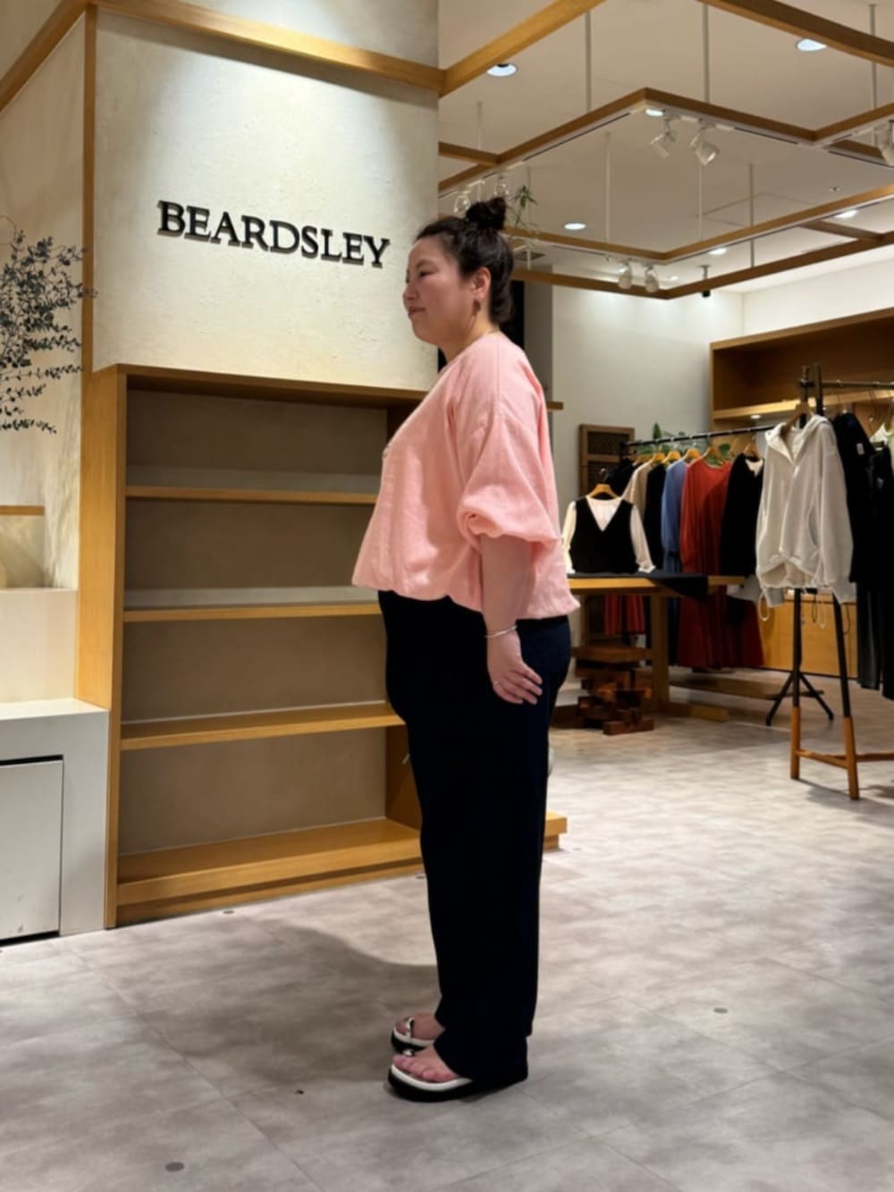 グレー系のボストンバッグ、ピンク系のシャツ/ブラウス、ホワイト系のサンダルを着用したレディースの冬コーディネートの3枚目の写真