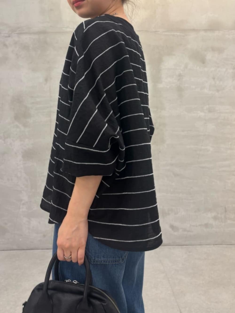 ブラック系のボストンバッグ、ブルー系のその他パンツ、ブラック系のシャツ/ブラウスを着用したレディースの春コーディネートの5枚目の写真