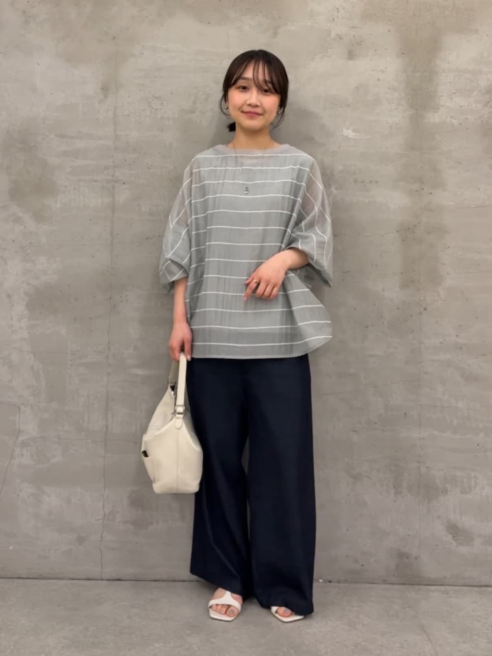 ブルー系のその他パンツ、ホワイト系のトートバッグ、グレー系のシャツ/ブラウスを着用したレディースの春コーディネートの2枚目の写真