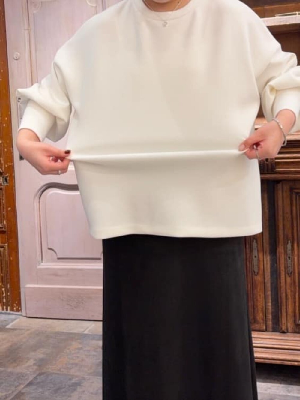 ブラック系のスカート、ブラック系のショルダーバッグ、ホワイト系のTシャツ/カットソーを着用したレディースの冬コーディネートの9枚目の写真