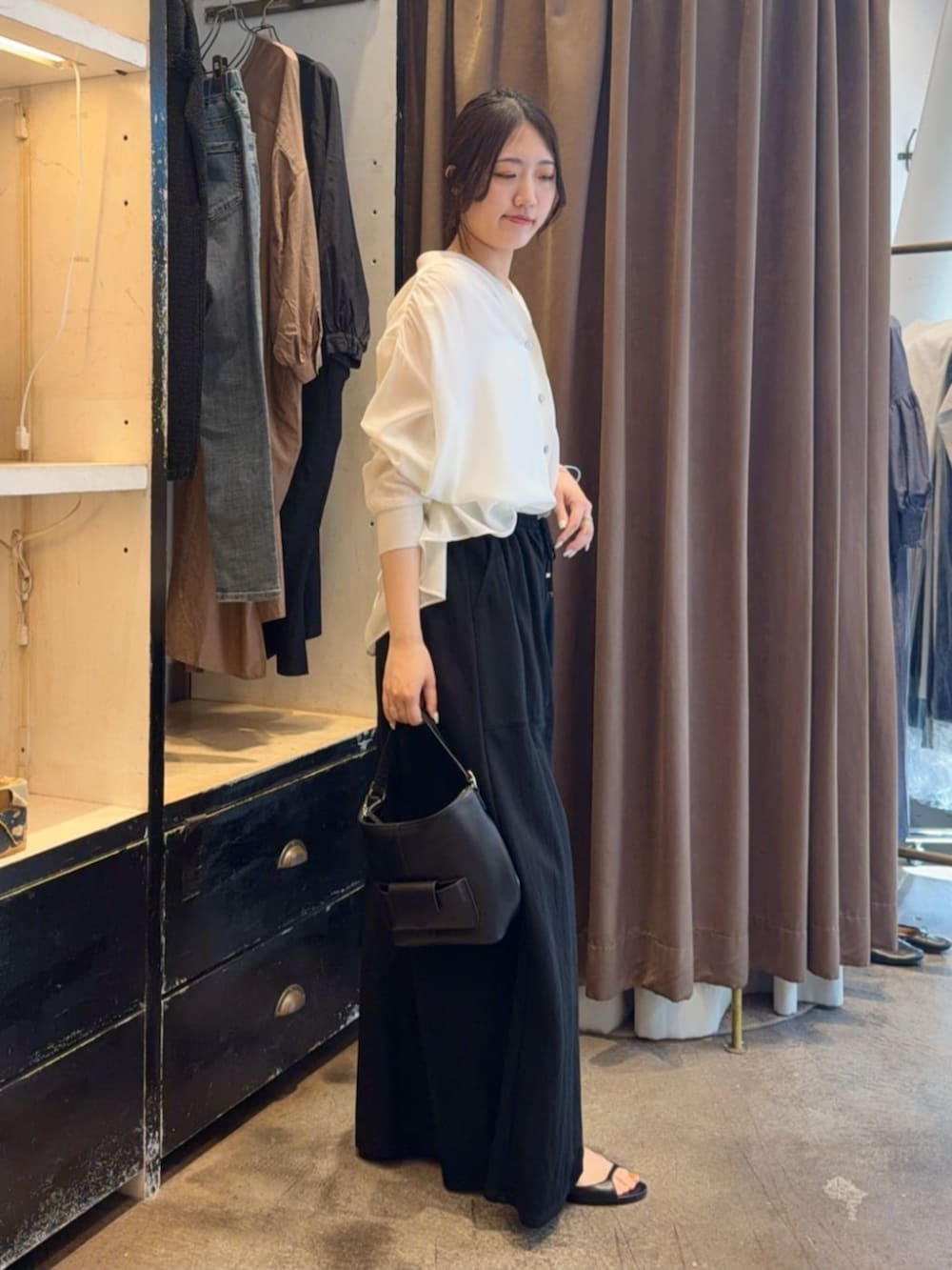 ブラック系のその他パンツ、ホワイト系のシャツ/ブラウスを着用したレディースの春コーディネートの2枚目の写真