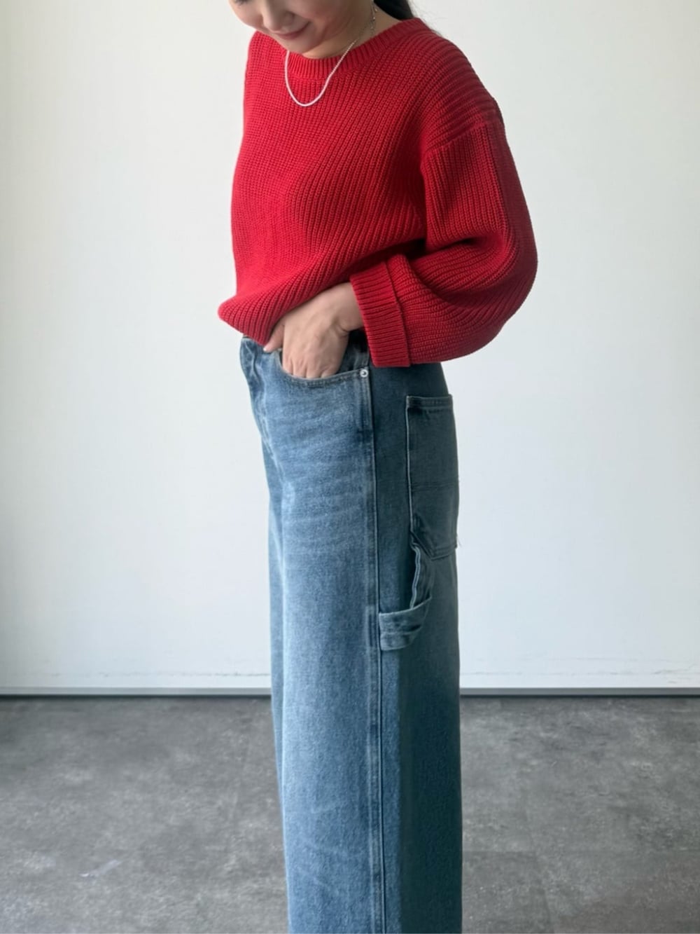 レッド系のニット/セーター、グレー系のトートバッグを着用したレディースの冬コーディネートの6枚目の写真