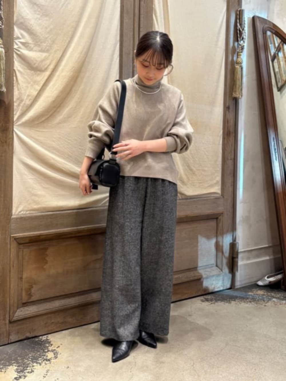 ブラック系のショルダーバッグ、ブラウン系のニット/セーター、グレー系のその他パンツを着用したレディースの秋コーディネートの3枚目の写真
