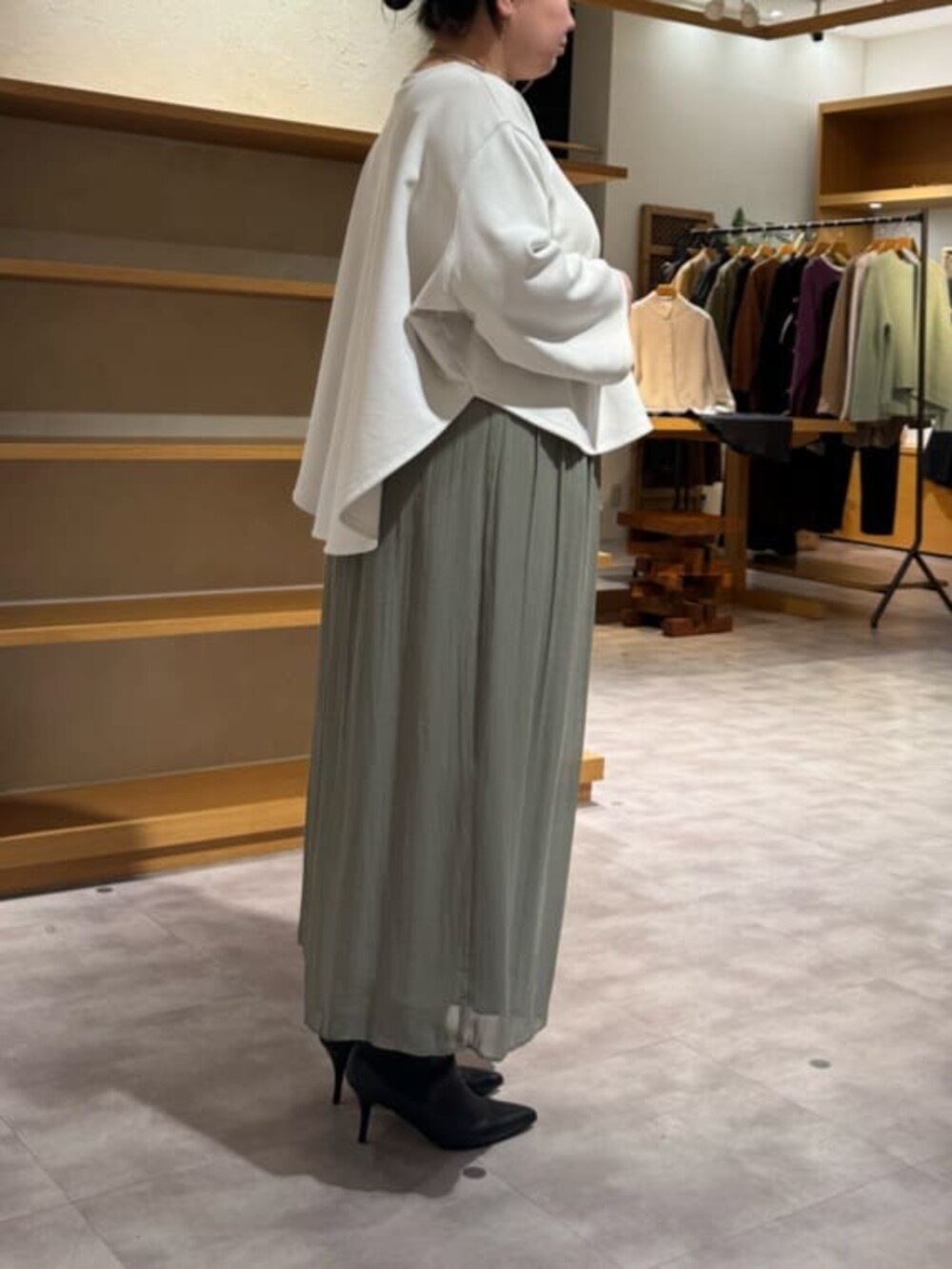 グリーン系のその他パンツ、ブラック系のブーツ、ブラック系のトートバッグを着用したレディースの冬コーディネートの6枚目の写真