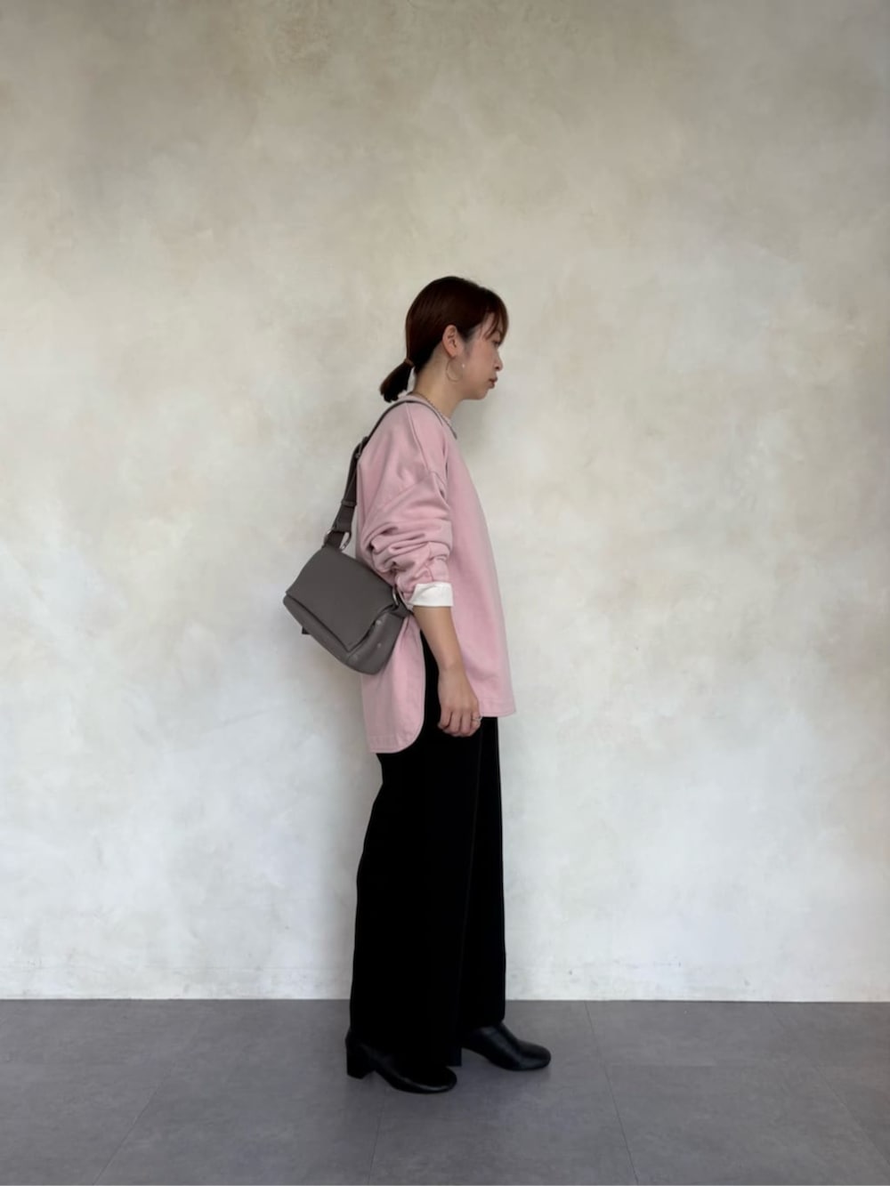 グレー系のショルダーバッグ、ピンク系のTシャツ/カットソー、ブラック系のその他パンツを着用したレディースの冬コーディネートの3枚目の写真