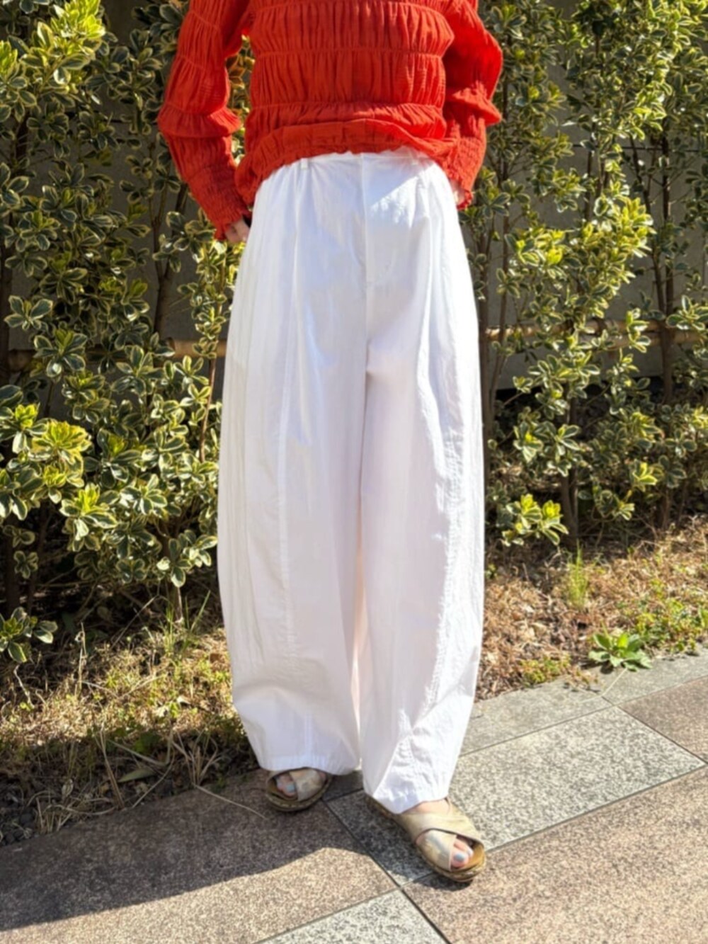 オレンジ系のシャツ/ブラウス、ホワイト系のその他パンツを着用したレディースの春コーディネートの8枚目の写真