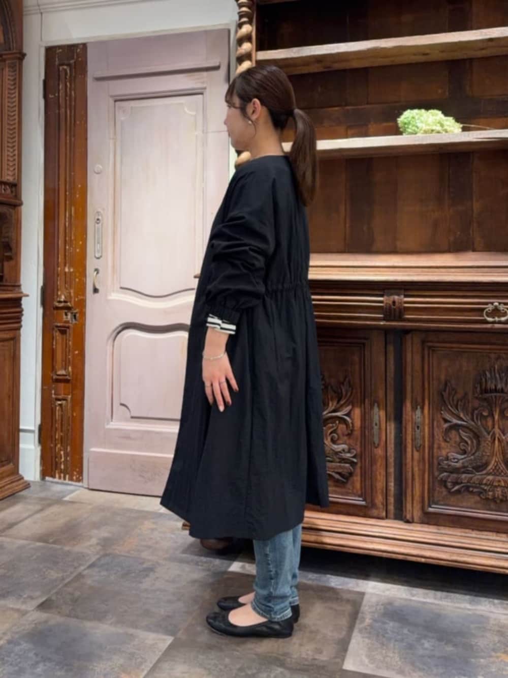 ブラック系のその他アウター、ブルー系のデニムパンツ、ブルー系のTシャツ/カットソーを着用したレディースの冬コーディネートの2枚目の写真