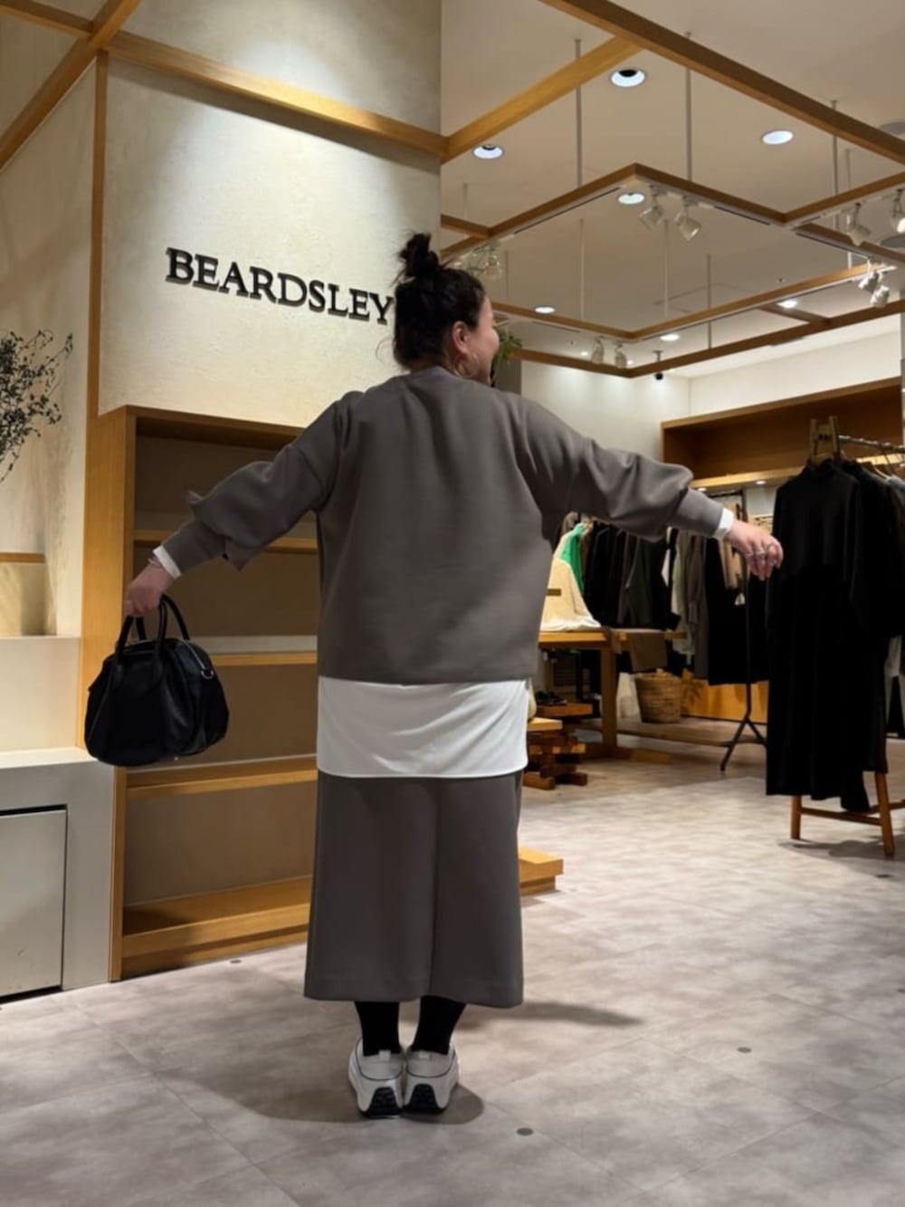 ホワイト系のスニーカー、ブラック系のボストンバッグ、ホワイト系のシャツ/ブラウスを着用したレディースの冬コーディネートの4枚目の写真