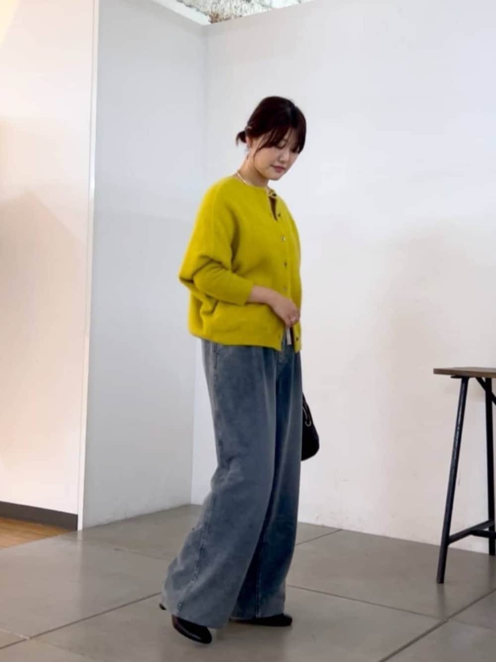 ブラック系のトートバッグ、イエロー系のニット/セーター、ブルー系のその他パンツを着用したレディースの秋コーディネートの5枚目の写真