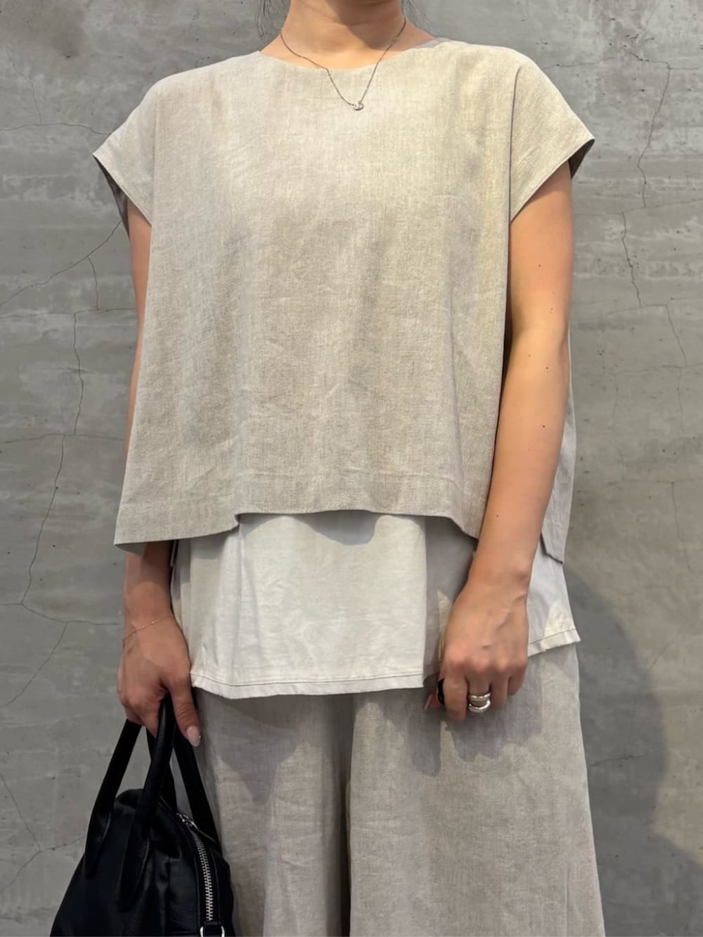 ブラック系のボストンバッグ、ホワイト系のサンダル、ホワイト系のシャツ/ブラウスを着用したレディースの春コーディネートの4枚目の写真