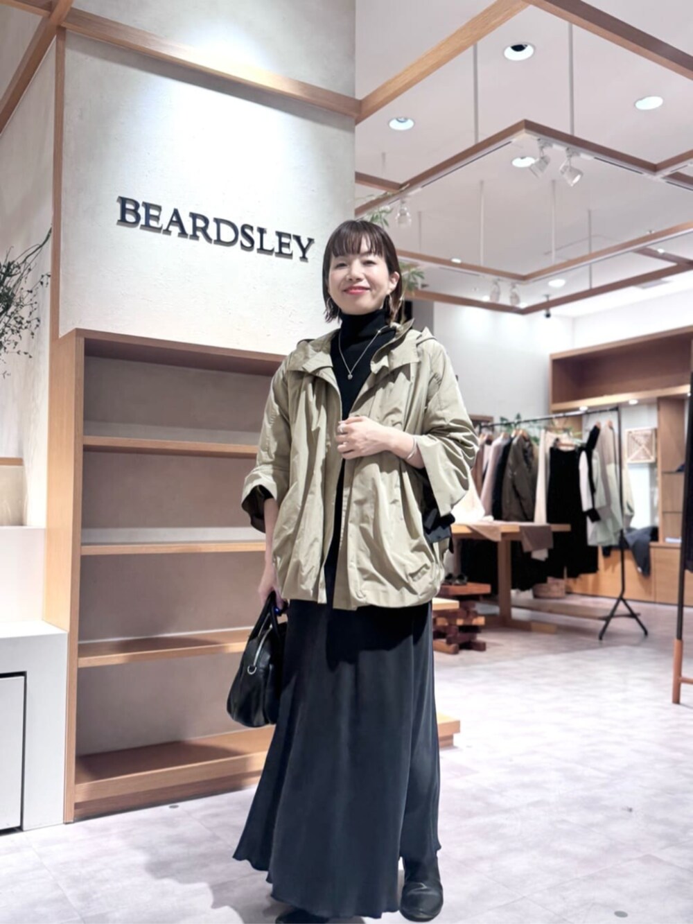 ブラック系のスカート、ブラウン系のブルゾンを着用したレディースの冬コーディネートの5枚目の写真