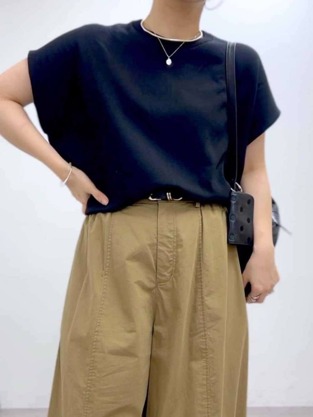 イエロー系のその他パンツ、ブラック系のニット/セーターを着用したレディースの夏コーディネートの3枚目の写真