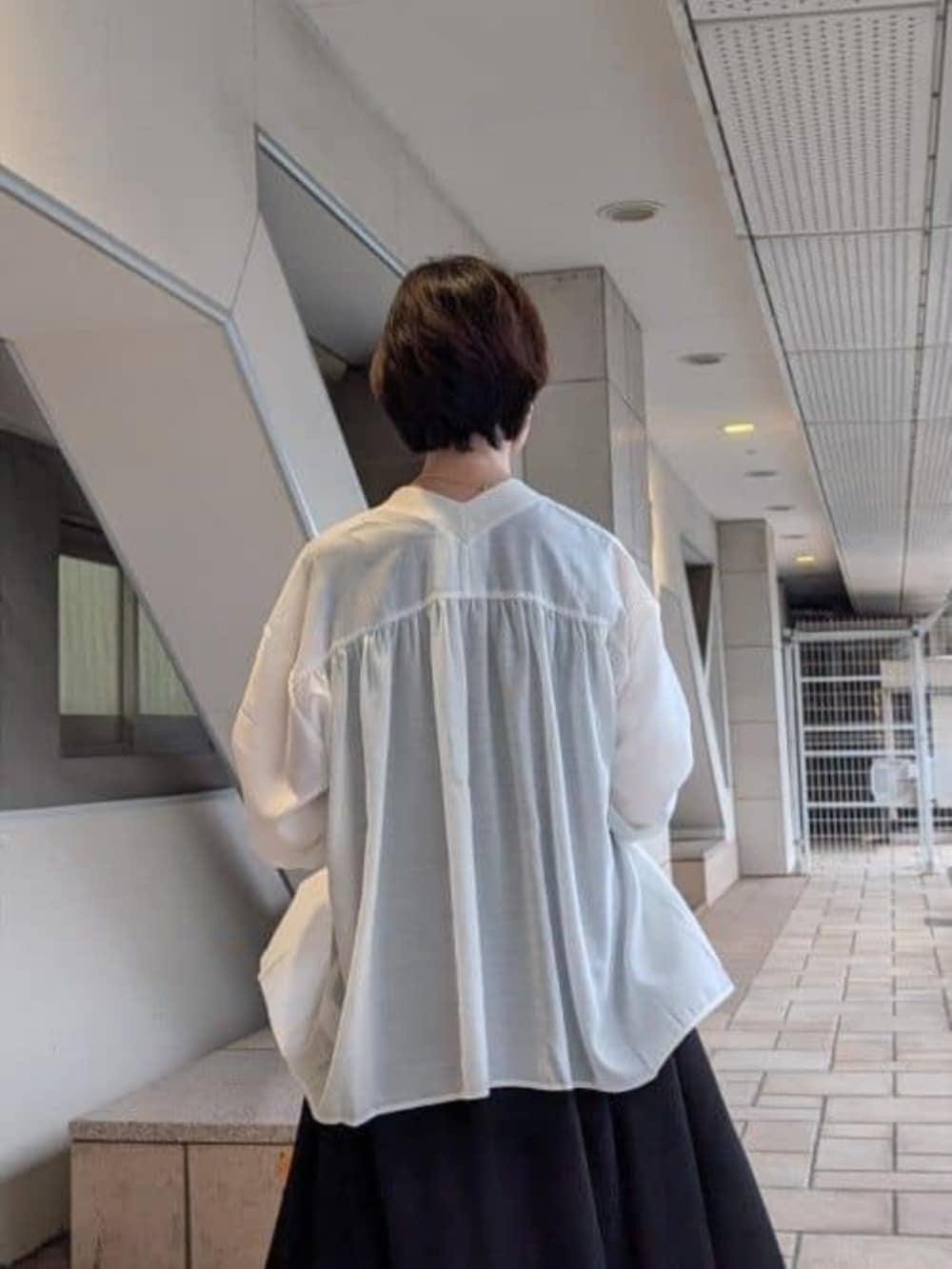ホワイト系のシャツ/ブラウス、ブラック系のワンピース、ブラック系のスニーカーを着用したレディースの夏コーディネートの6枚目の写真