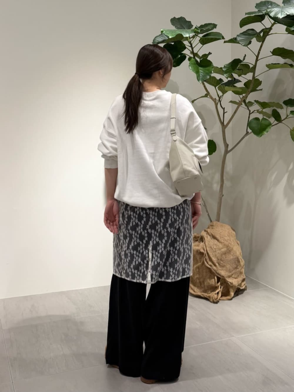 ブラック系のその他パンツ、グレー系のニット/セーター、ホワイト系のTシャツ/カットソーを着用したレディースの春コーディネートの4枚目の写真