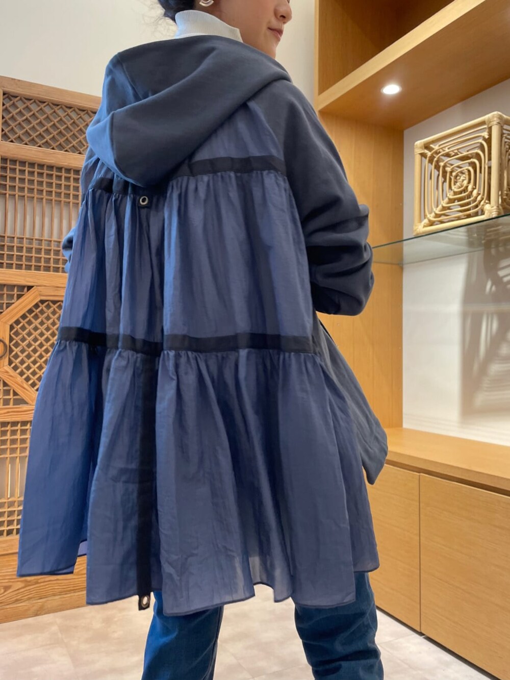 ブルー系のパーカー、ホワイト系のニット/セーター、ブルー系のデニムパンツを着用したレディースの春コーディネートの4枚目の写真