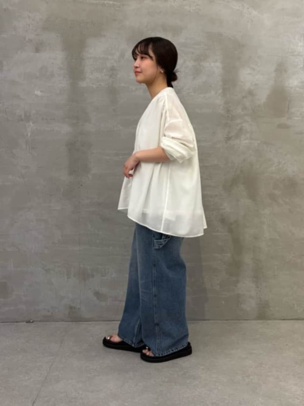 ホワイト系のショルダーバッグ、ブラック系のサンダル、ブルー系のその他パンツを着用したレディースの冬コーディネートの3枚目の写真