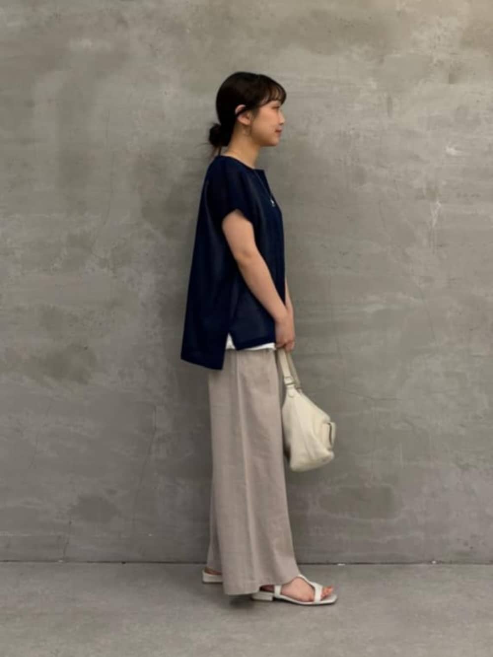 ホワイト系のトートバッグ、グレー系のその他パンツ、ブルー系のニット/セーターを着用したレディースの春コーディネートの2枚目の写真