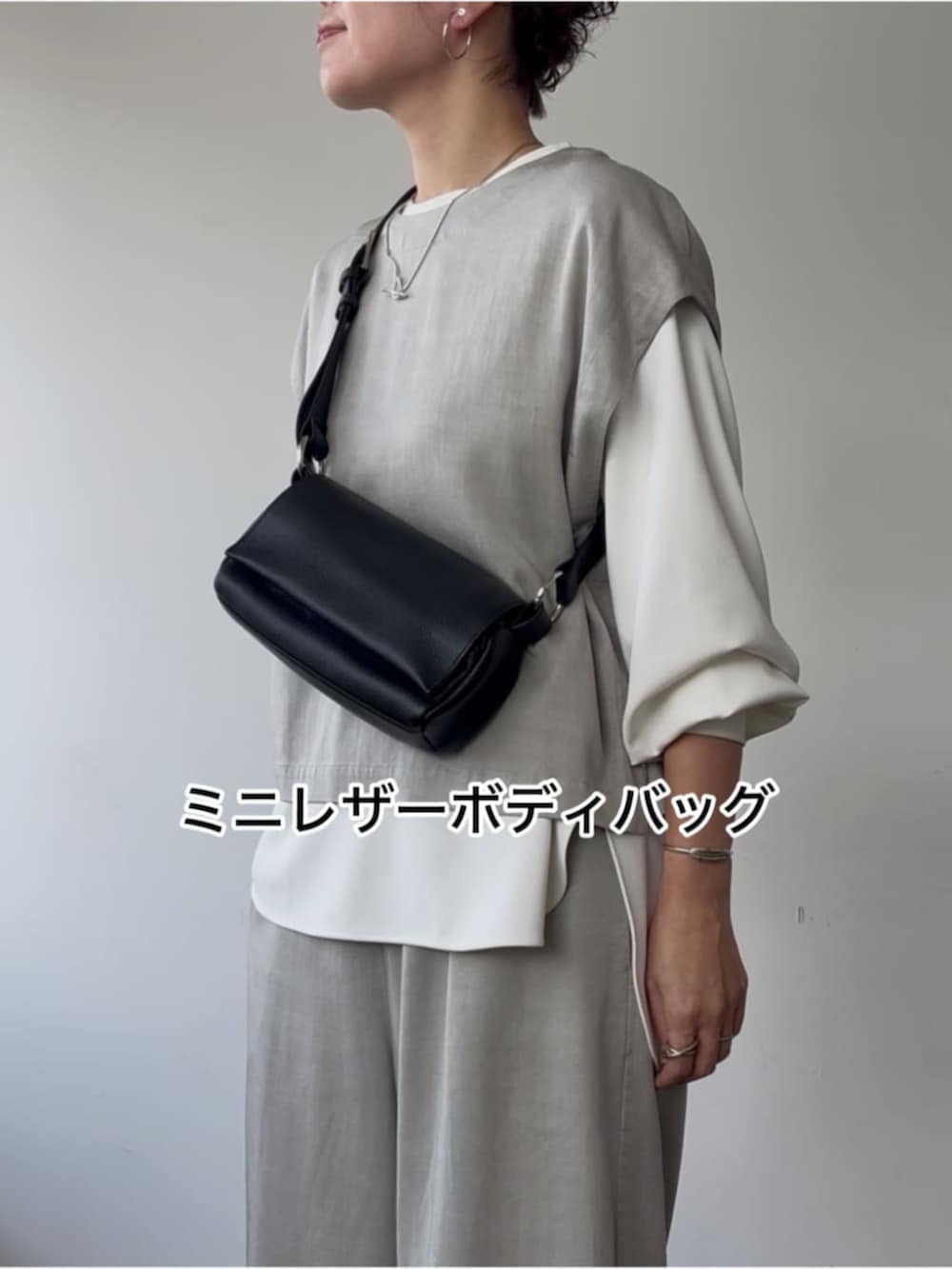 グレー系のシャツ/ブラウス、ブラック系のショルダーバッグ、ホワイト系のシャツ/ブラウスを着用したレディースの冬コーディネートの7枚目の写真