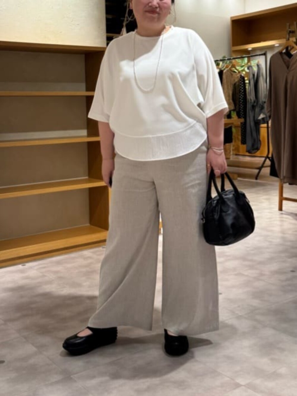 ブラック系のボストンバッグ、ベージュ系のその他パンツ、ホワイト系のTシャツ/カットソーを着用したレディースの春コーディネートの6枚目の写真