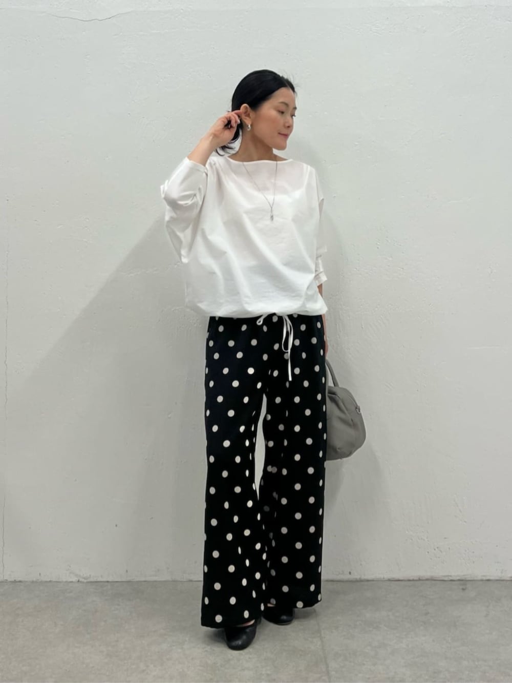 グレー系のボストンバッグ、ホワイト系のシャツ/ブラウス、ブラック系のその他パンツを着用したレディースの冬コーディネートの2枚目の写真