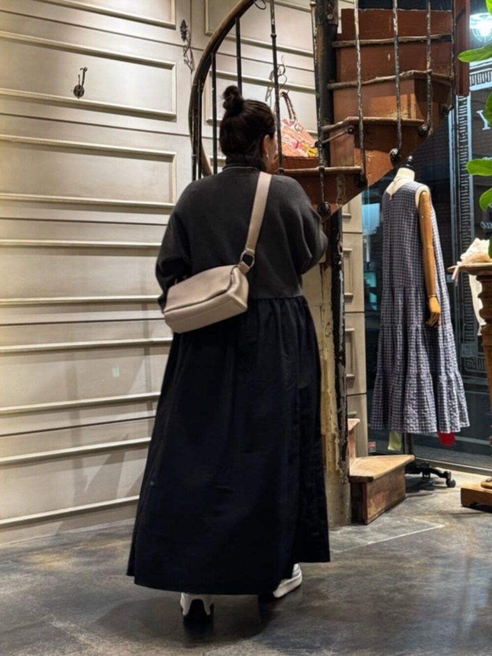 グレー系のワンピース、ベージュ系のショルダーバッグを着用したレディースの冬コーディネートの2枚目の写真