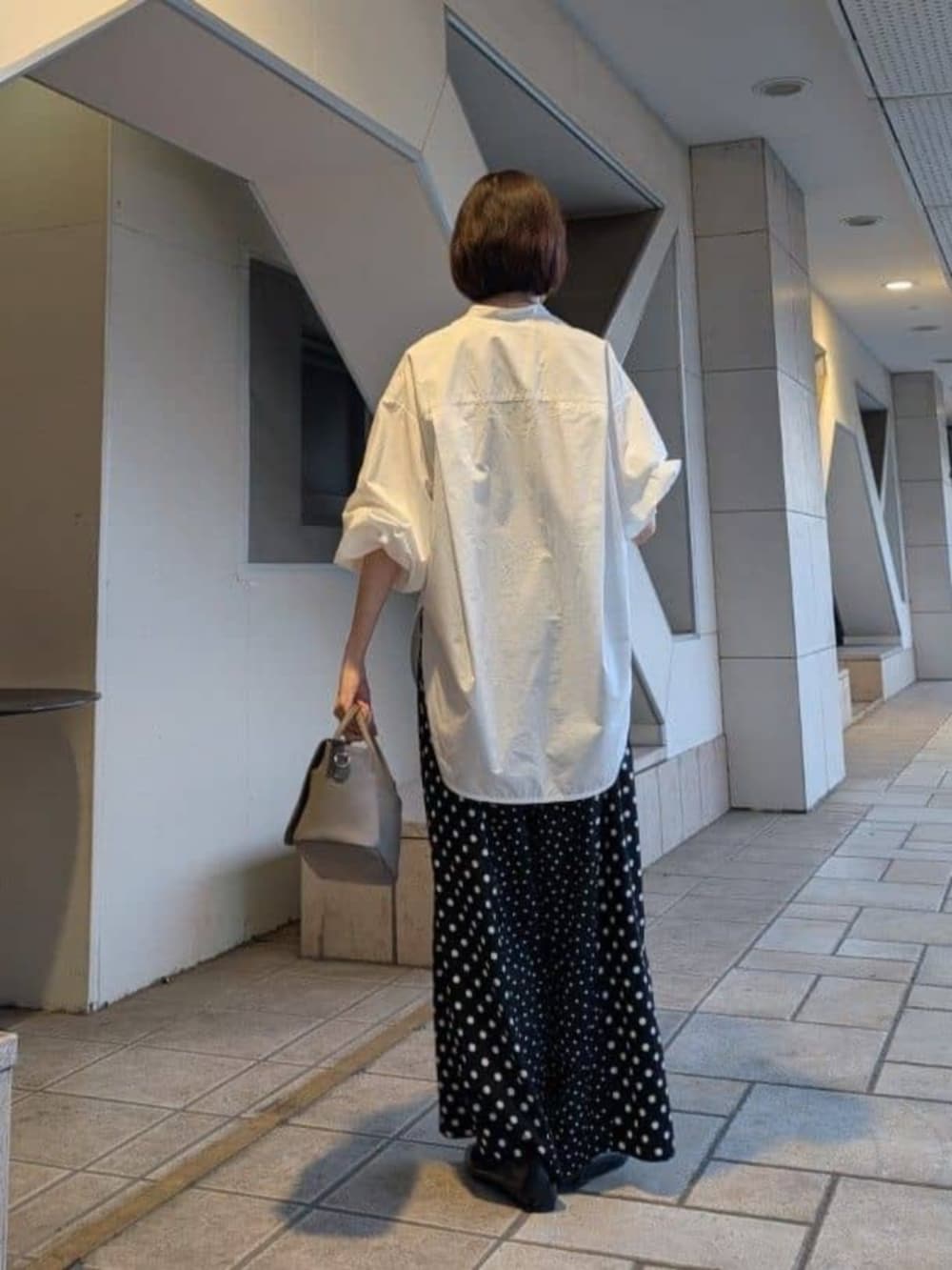 ブラック系のパンプス、ホワイト系のシャツ/ブラウスを着用したレディースの冬コーディネートの4枚目の写真