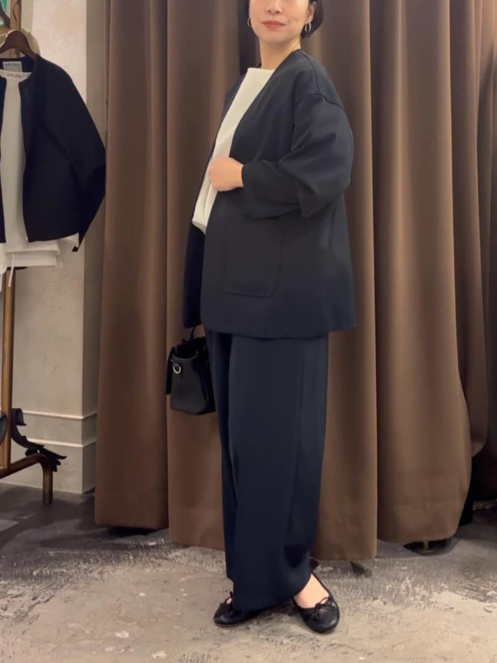 ブラック系のハンドバッグ、ブラック系のその他アウター、ブラック系のその他パンツを着用したレディースの春コーディネートの2枚目の写真