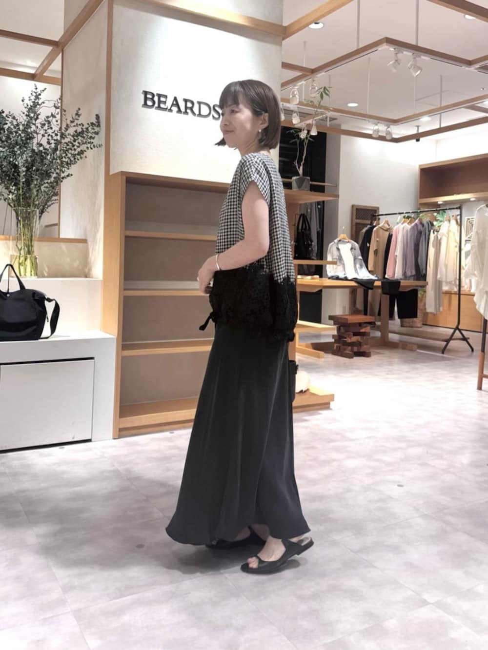 ブラック系のスカート、ブラック系のハンドバッグ、ブラック系のシャツ/ブラウスを着用したレディースの春コーディネートの3枚目の写真