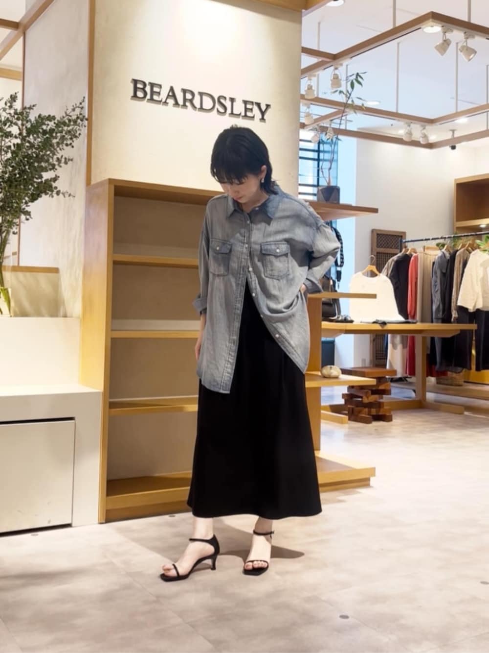 ブルー系のシャツ/ブラウス、ブラック系のワンピースを着用したレディースの春コーディネートの4枚目の写真