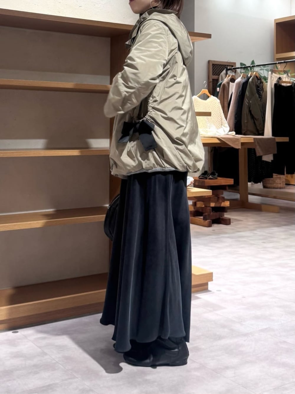 ブラック系のスカート、ブラウン系のブルゾンを着用したレディースの冬コーディネートの8枚目の写真