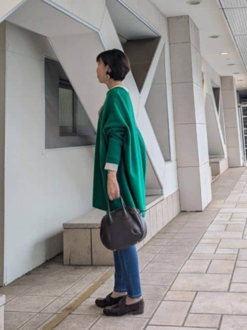 ブルー系のデニムパンツ、ブラウン系のその他シューズ、ブラウン系のトートバッグを着用したレディースの秋コーディネートの2枚目の写真