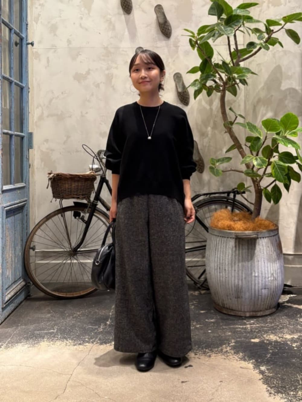 ブラック系のニット/セーター、グレー系のその他パンツを着用したレディースの夏コーディネートの2枚目の写真