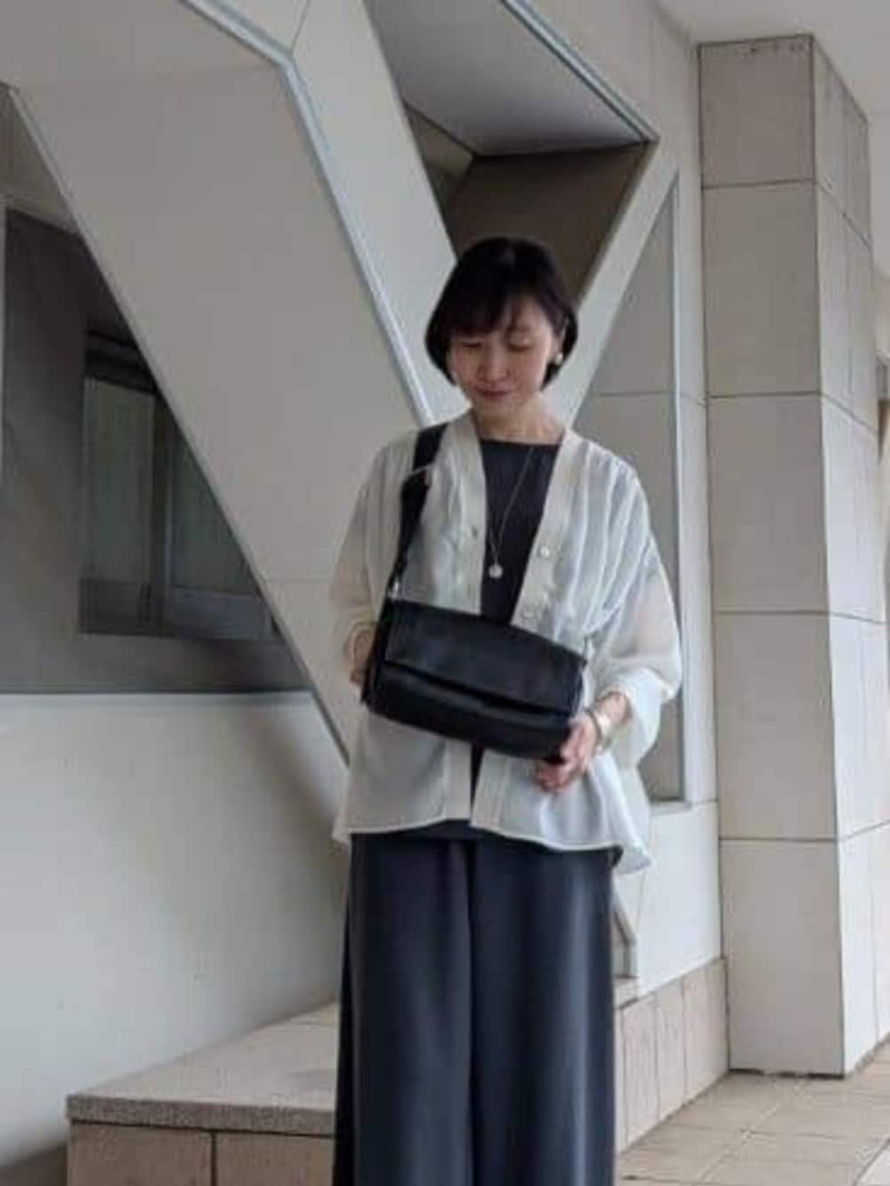 グレー系のその他パンツ、ホワイト系のシャツ/ブラウス、ホワイト系のスニーカーを着用したレディースの春コーディネートの3枚目の写真