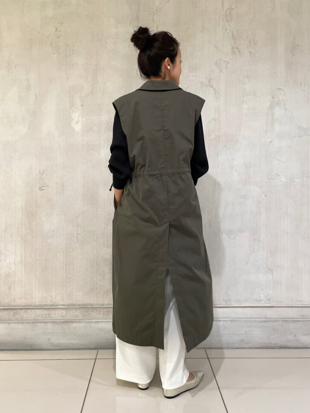 ブラック系のシャツ/ブラウス、グリーン系のトレンチコート、ホワイト系のその他パンツを着用したレディースの秋コーディネートの2枚目の写真