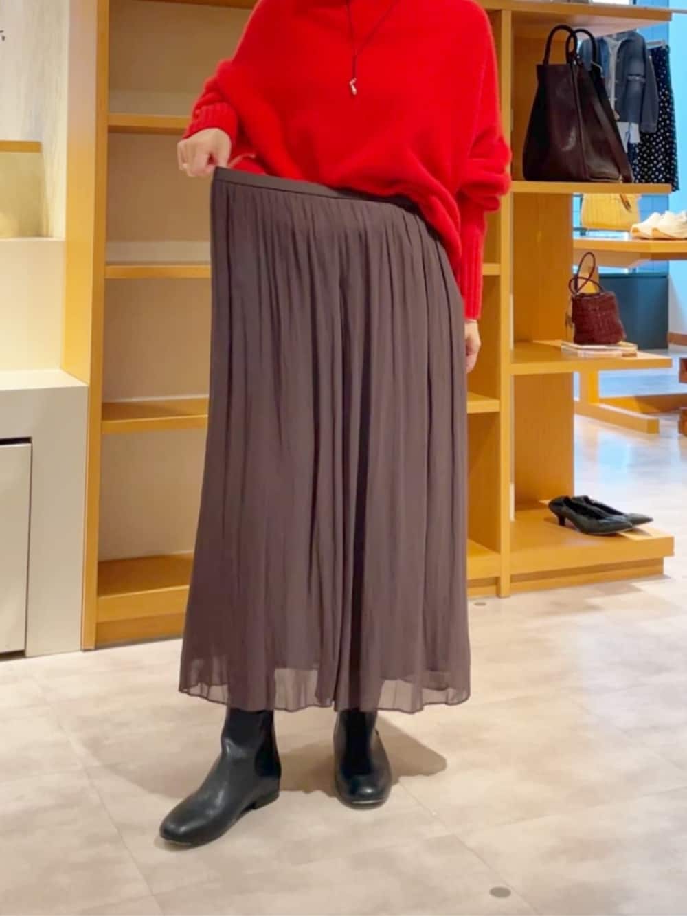 ブラウン系のその他パンツ、ブラック系のノーカラーコート、ブラック系のブーツを着用したレディースの冬コーディネートの10枚目の写真