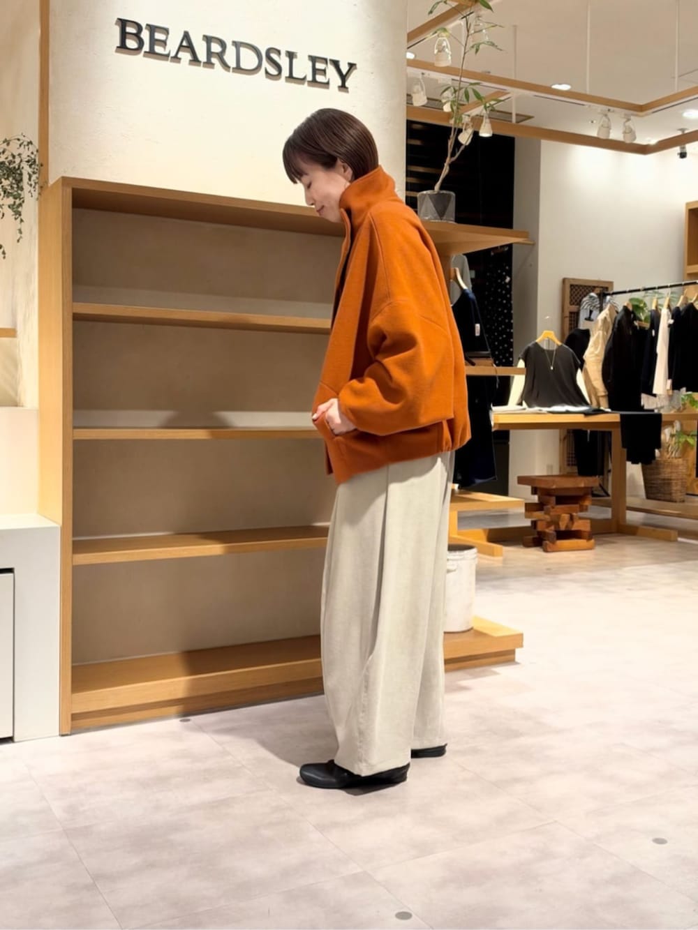 グレー系のその他パンツ、オレンジ系のその他アウターを着用したレディースの秋コーディネートの5枚目の写真