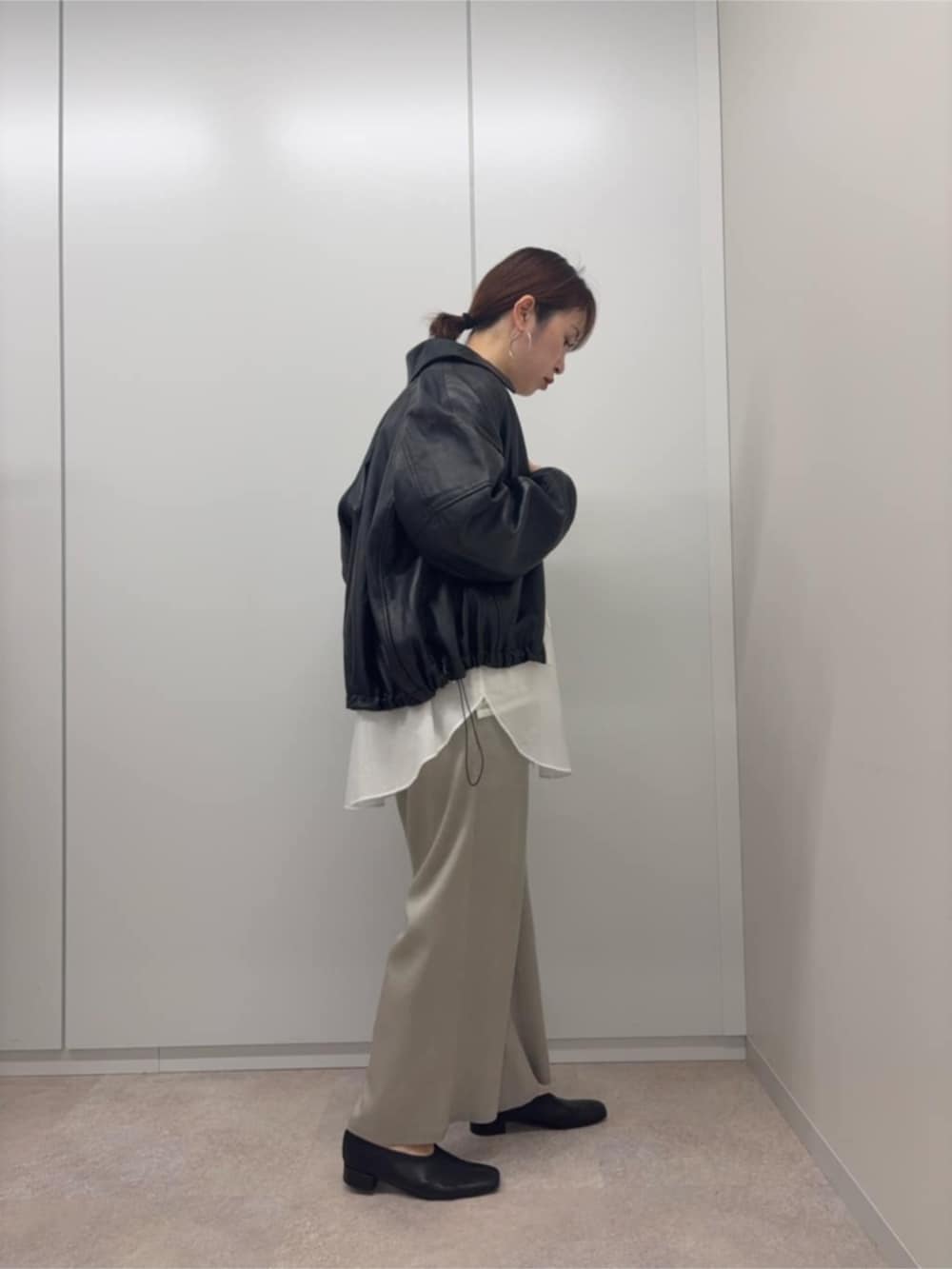 ブラック系のブルゾン、ホワイト系のシャツ/ブラウスを着用したレディースの冬コーディネートの2枚目の写真