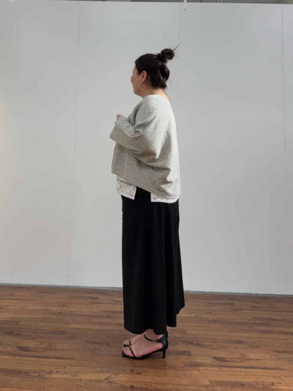 ブラック系のボストンバッグ、ホワイト系のシャツ/ブラウス、グレー系のカーディガン/ボレロを着用したレディースの春コーディネートの6枚目の写真