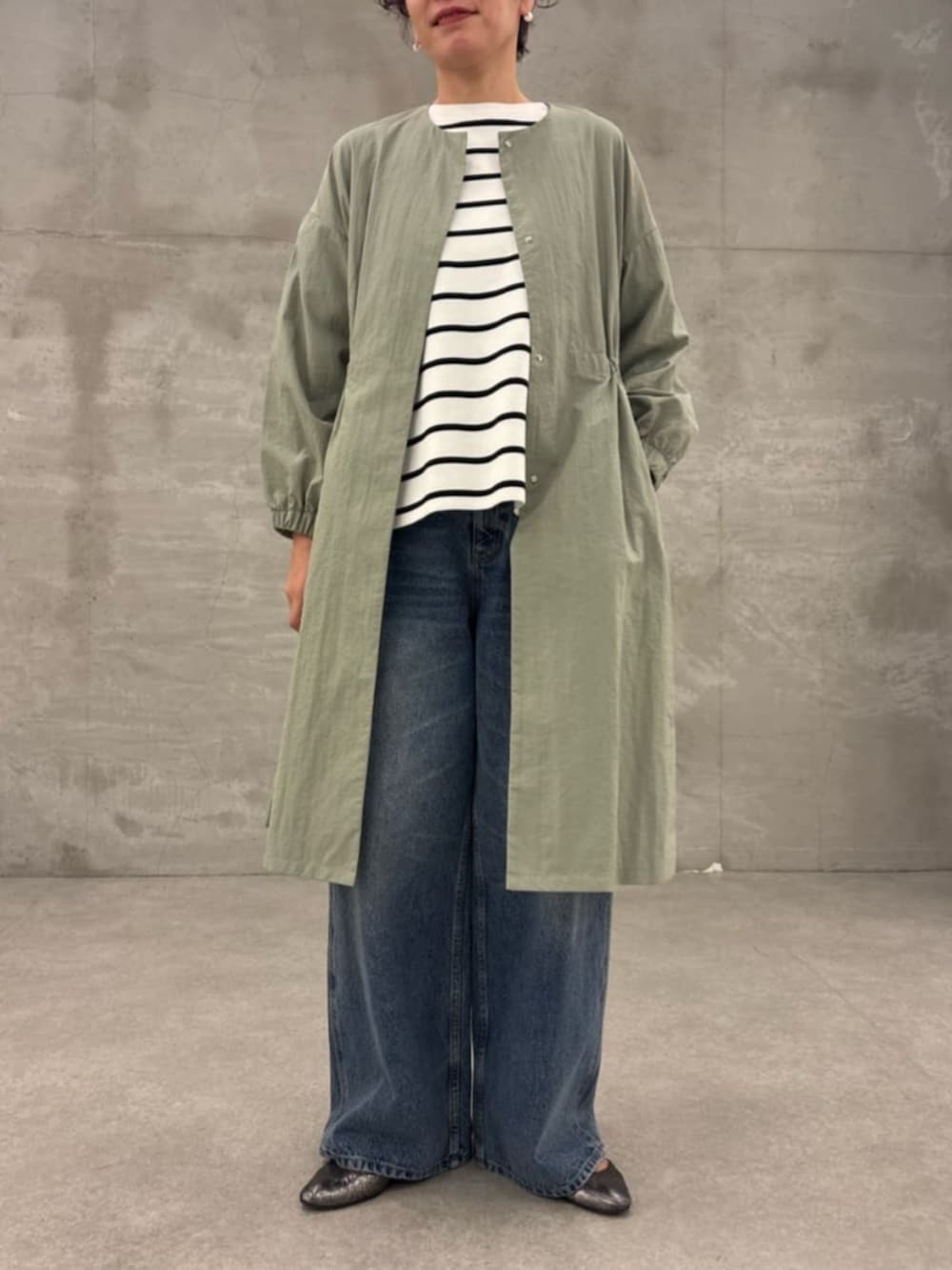 ブラック系のショルダーバッグ、グリーン系のその他アウター、ホワイト系のニット/セーターを着用したレディースの冬コーディネートの5枚目の写真