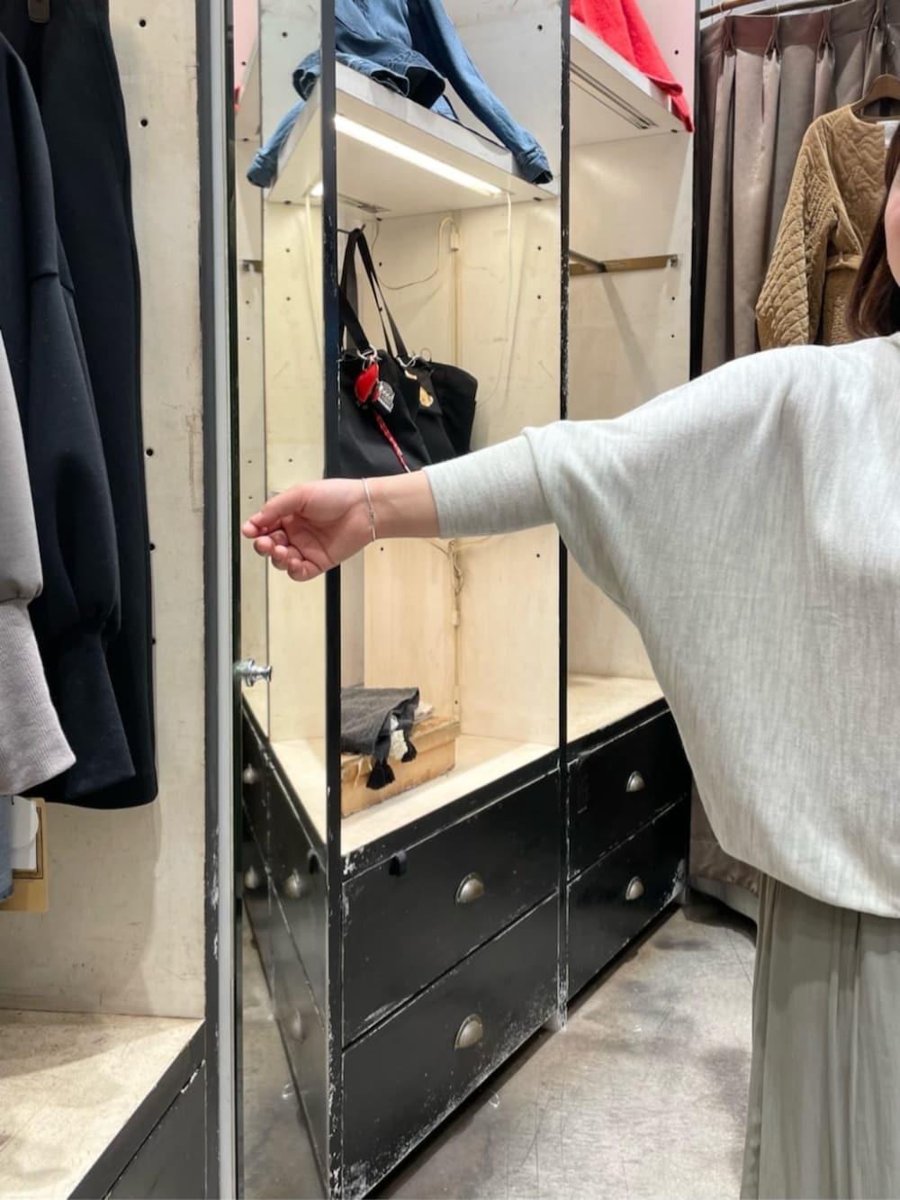 グレー系のニット/セーター、グリーン系のその他パンツ、ブラック系のトートバッグを着用したレディースの冬コーディネートの6枚目の写真