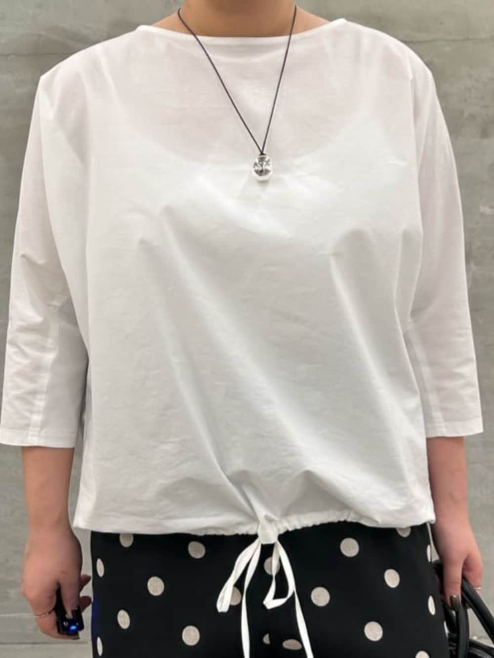 ブラック系のボストンバッグ、ホワイト系のシャツ/ブラウス、ブラック系のその他パンツを着用したレディースの冬コーディネートの6枚目の写真