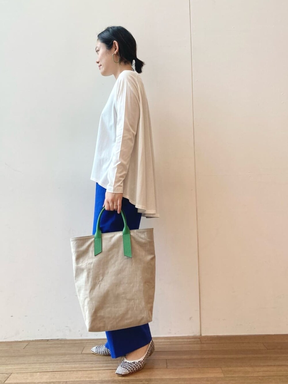 ホワイト系のTシャツ/カットソー、ブルー系のその他パンツ、グリーン系のトートバッグを着用したレディースの春コーディネートの2枚目の写真