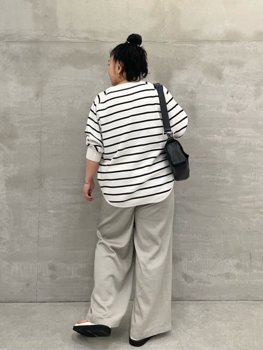 ブラック系のショルダーバッグ、ホワイト系のニット/セーター、ホワイト系のサンダルを着用したレディースの冬コーディネートの4枚目の写真