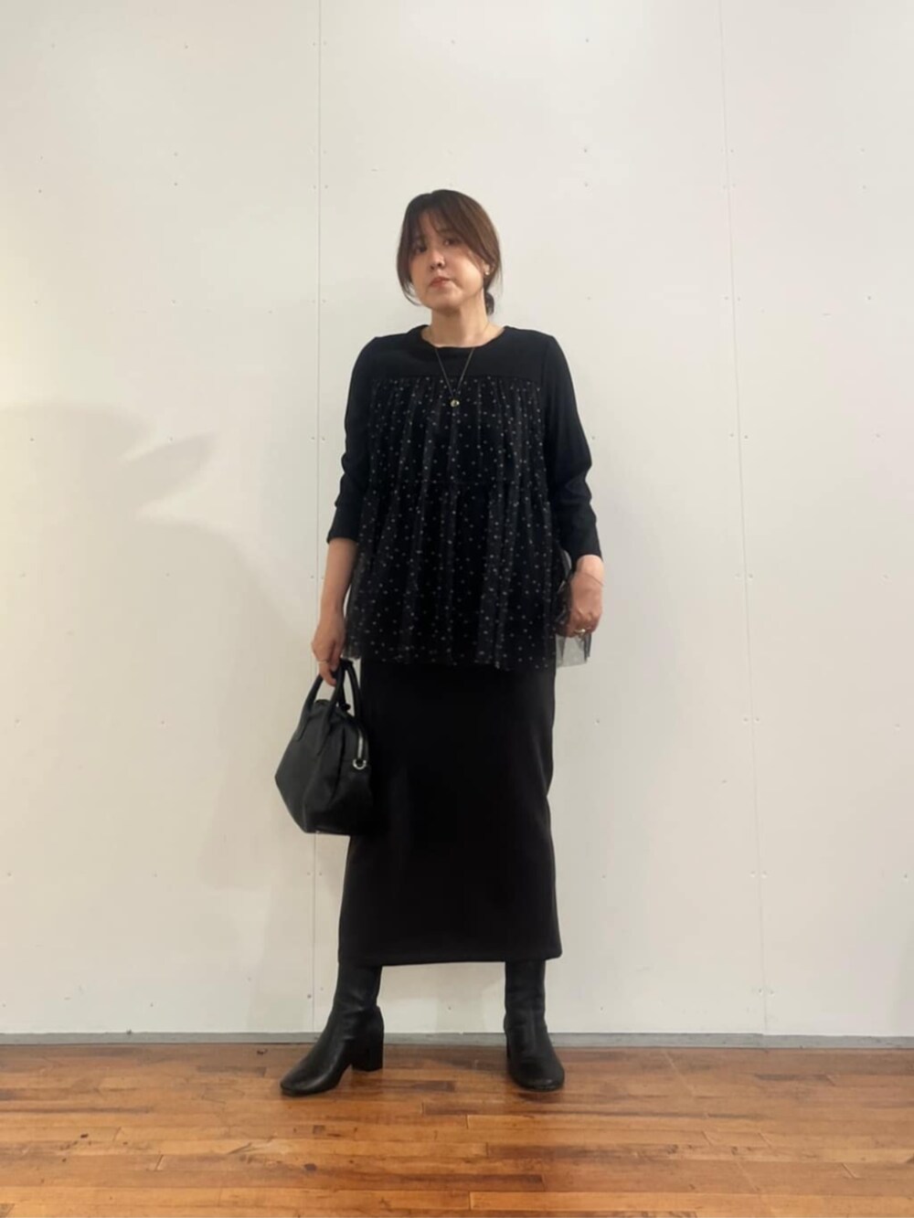ブラック系のボストンバッグ、グレー系のスカート、ブラック系のTシャツ/カットソーを着用したレディースの夏コーディネートの6枚目の写真