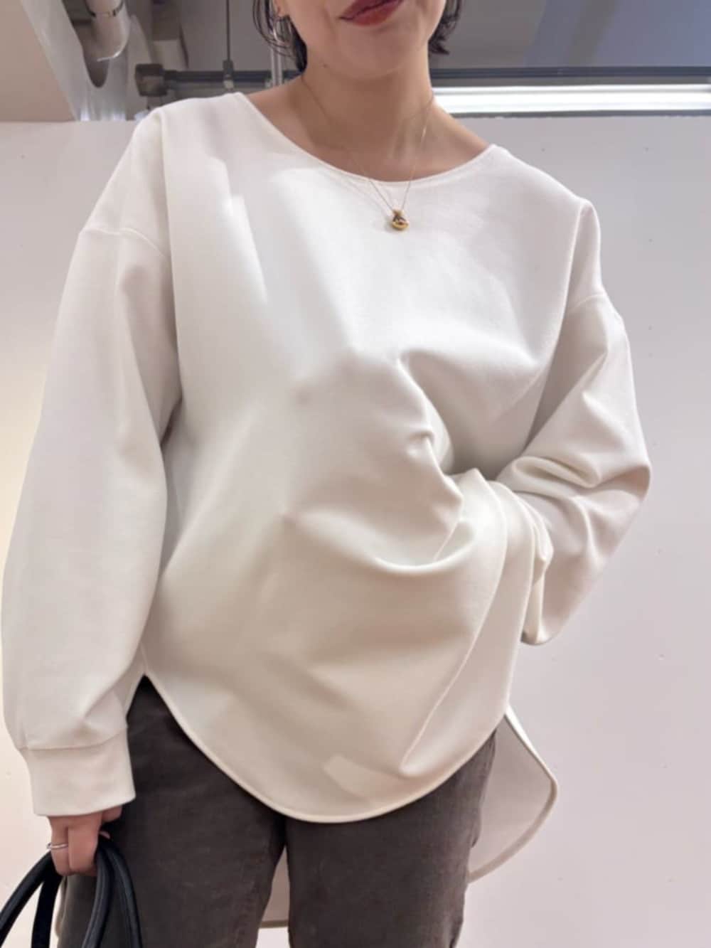 ブルー系のデニムパンツ、ブラック系のトートバッグ、ブルー系のニット/セーターを着用したレディースの秋コーディネートの8枚目の写真