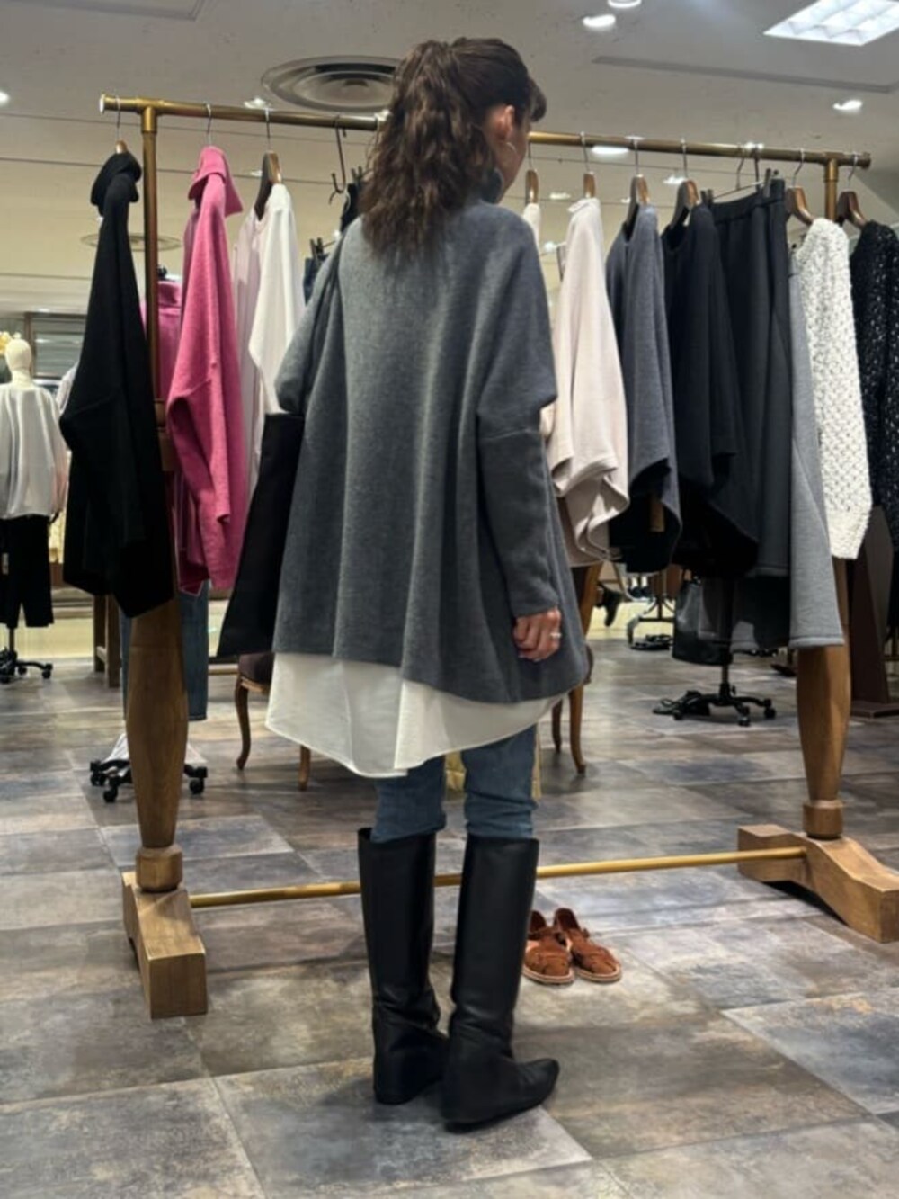 ブルー系のデニムパンツ、グレー系のニット/セーター、ホワイト系のシャツ/ブラウスを着用したレディースの冬コーディネートの2枚目の写真