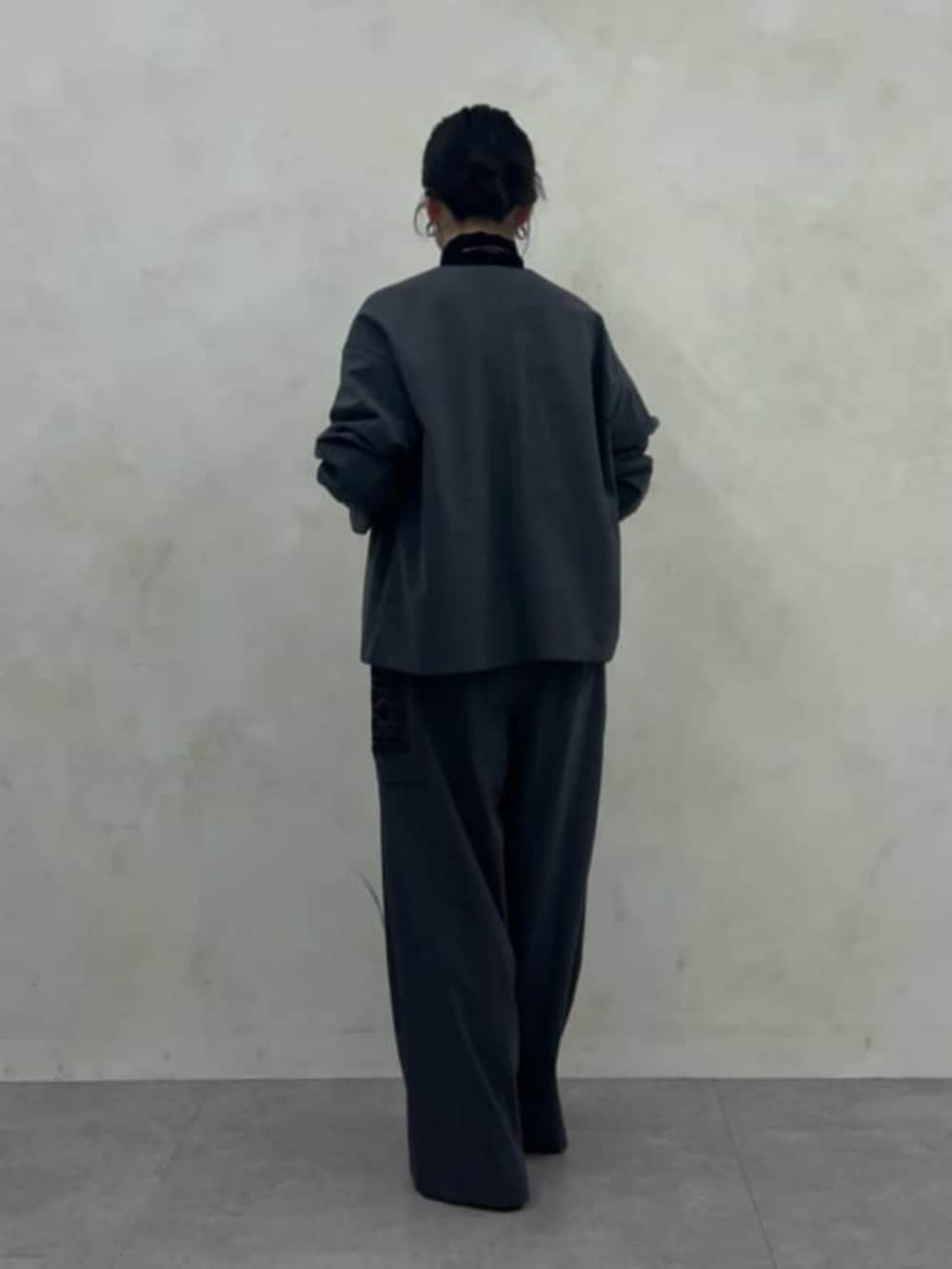 ブラック系のニット/セーター、グレー系のその他パンツ、グレー系のテーラードジャケットを着用したレディースの秋コーディネートの3枚目の写真